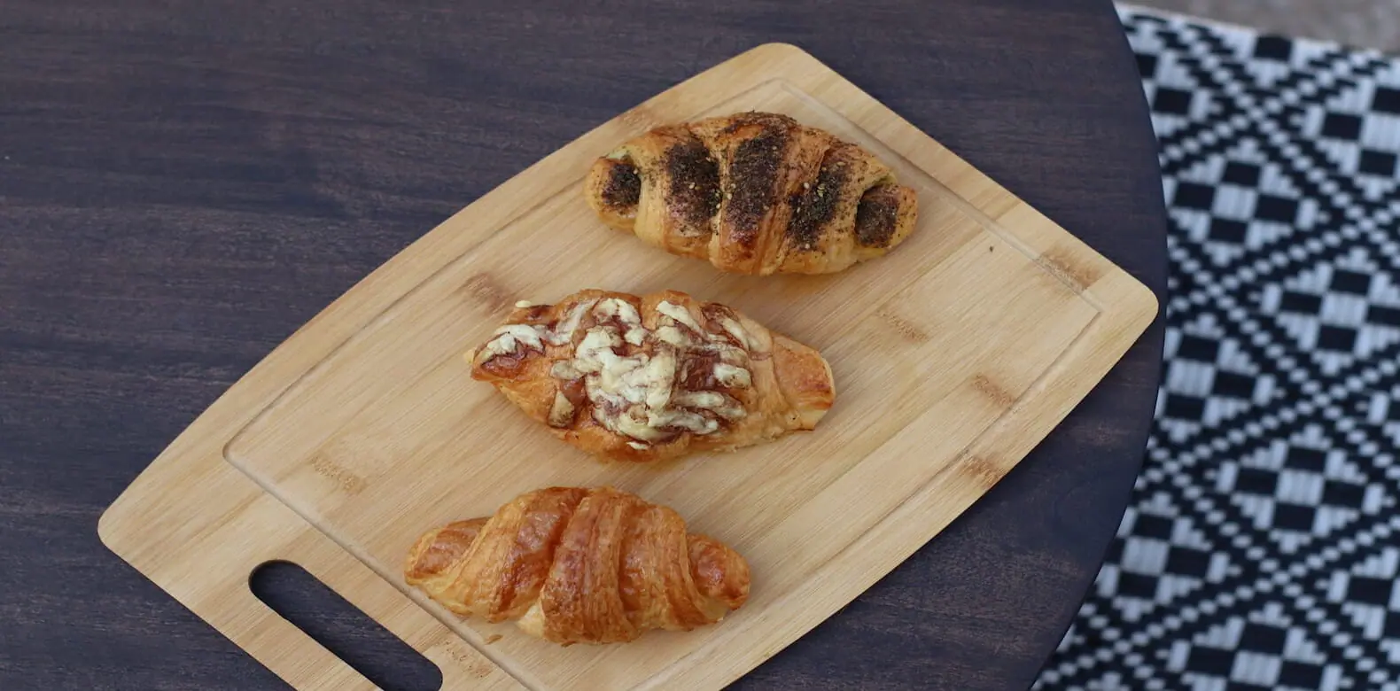 Freshly baked croissants on a wooden board